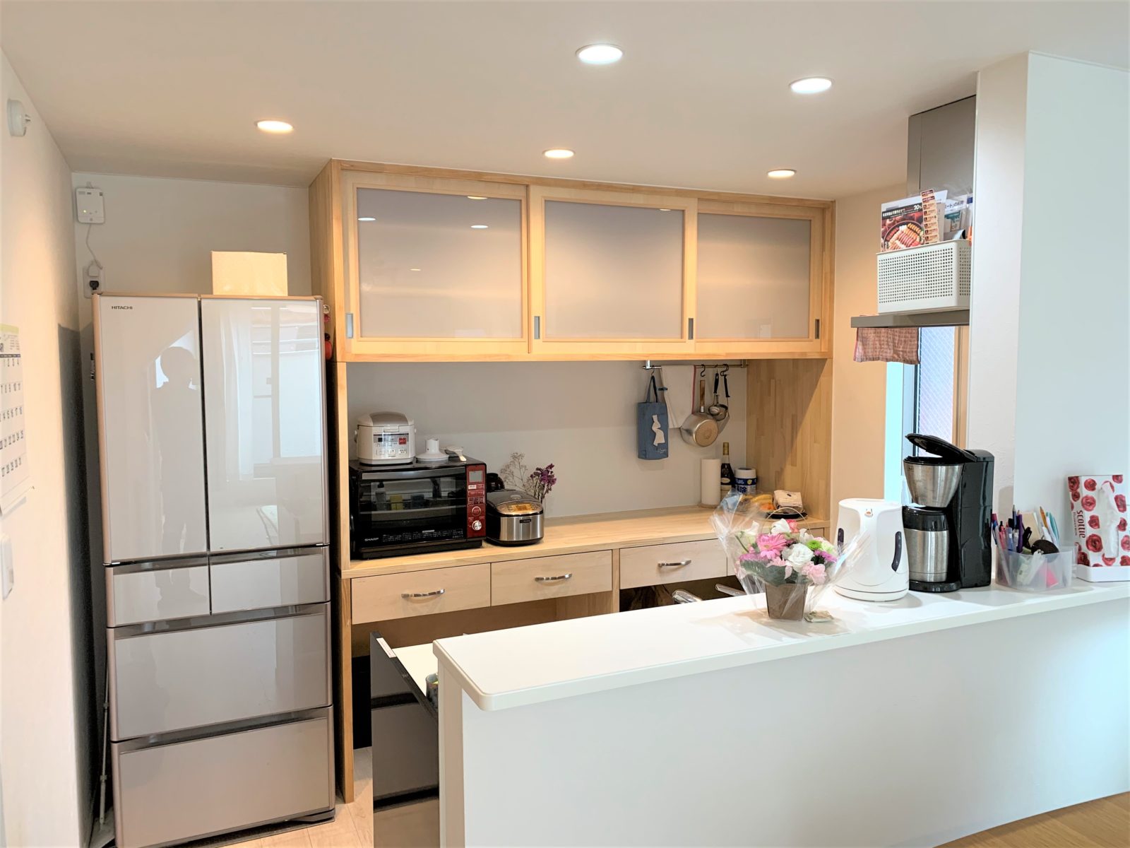 白い壁紙、明るい内装に合うナチュラルな印象のキッチン